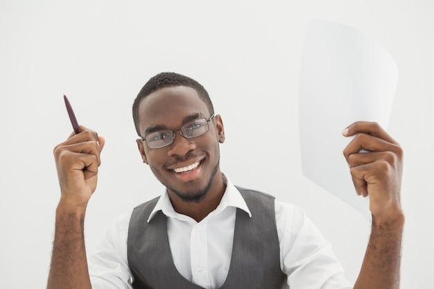 Heureux homme d&#39;affaires montrant un crayon et une page