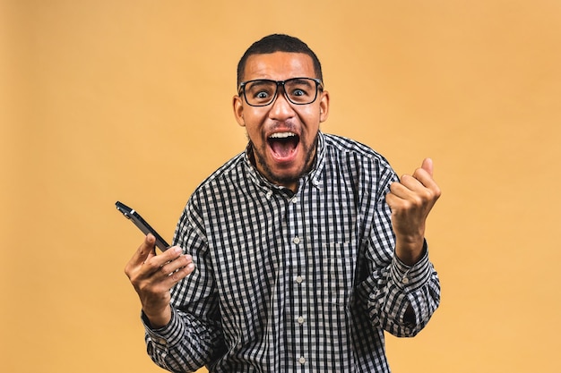 Heureux homme afro-américain sachant qu'il est devenu le gagnant de quelque chose de si réjouissant en appréciant les nouvelles