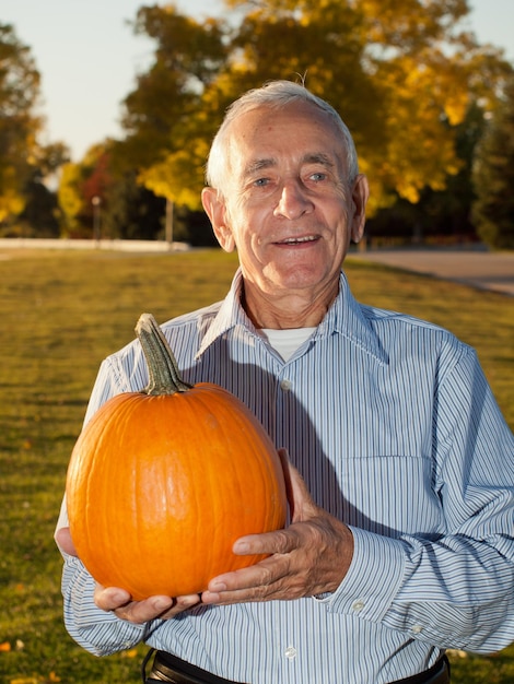 Heureux homme âgé avec des citrouilles.