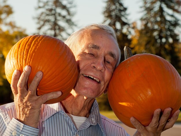 Heureux homme âgé avec des citrouilles.