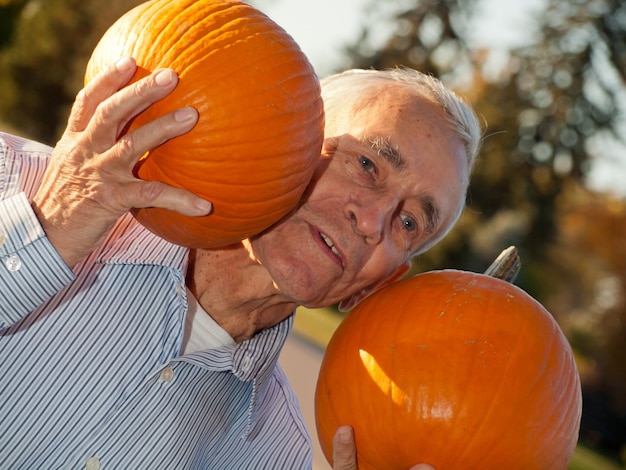 Heureux homme âgé avec des citrouilles.