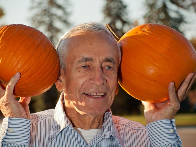 Heureux homme âgé avec des citrouilles.