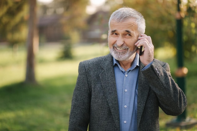 Heureux homme âgé parler avec quelqu'un par téléphone