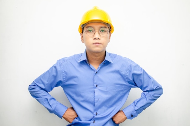 heureux homme asiatique extatique ouvrier du bâtiment en chemise bleue avec casque de sécurité jaune