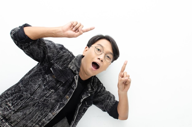Heureux homme asiatique extatique porter une veste jeans pointant le doigt pour copier l'espace présentant et montrant.