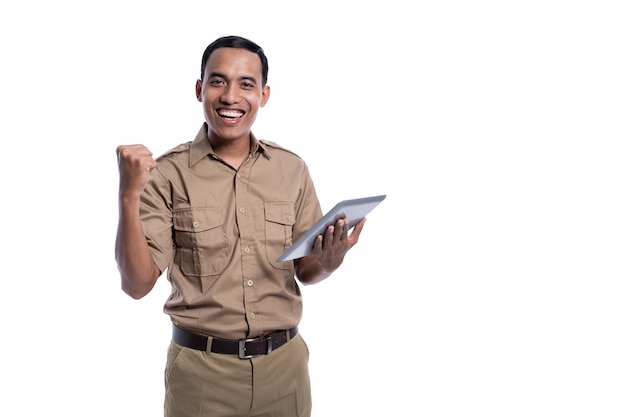 Heureux homme asiatique portant un uniforme kaki à l'aide d'une tablette