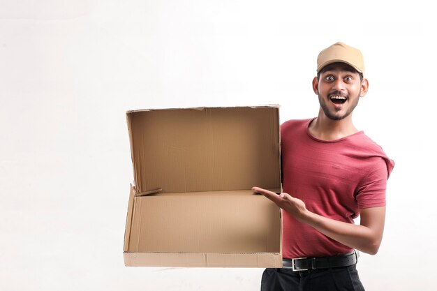 Heureux homme asiatique en t-shirt et casquette tenant une boîte vide isolée sur fond blanc, concept de service de livraison