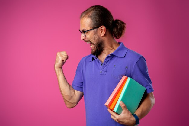 Heureux homme barbu drôle dans des verres célébrant le succès contre le rose