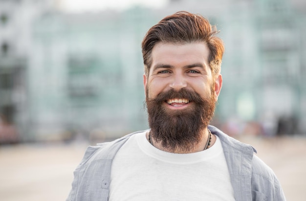 Heureux homme barbu à pied à l'extérieur du visage de l'homme à la barbe homme décontracté brutal en plein air