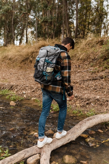 Heureux homme de camping dans la forêt par derrière