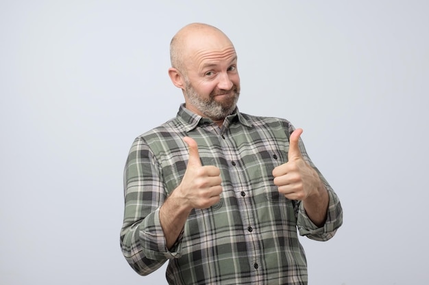 Heureux homme caucasien avec le geste du pouce levé approuvant votre choix