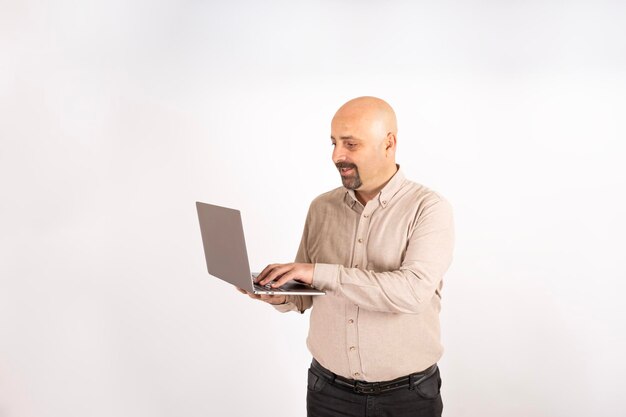 Heureux homme caucasien tenant un ordinateur portable travaillant en ligne. Doigts sur le clavier. Concept de navigation sur Internet.