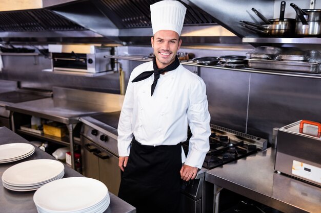 Heureux homme chef debout dans la cuisine