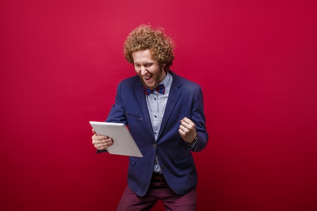 Heureux homme en costume avec tablette