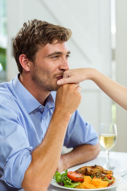 Heureux homme embrassant la main de la femme à la maison