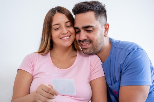 heureux homme enceinte et femme assise regardant une photo d'échographie