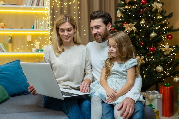 Heureux homme de famille femme et fille célébrant le nouvel an et noël ensemble couple assis sur