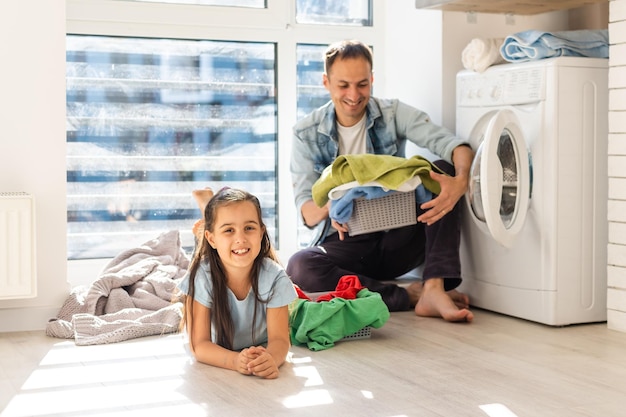 Heureux homme de famille père maître de maison et enfant fille dans la lessive avec machine à laver