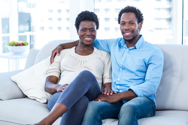 Heureux homme avec une femme enceinte assis à la maison