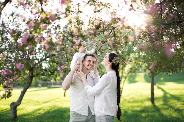 Heureux homme et femme jouant avec bébé à l'extérieur