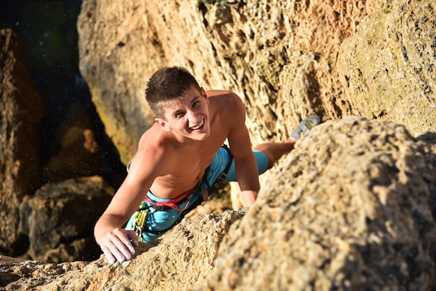 Heureux homme grimpant sur un rocher