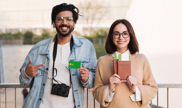 Heureux homme indien millénaire femme caucasienne les touristes montrent des billets de passeport et une carte de crédit