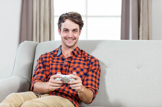 Heureux homme jouant à des jeux vidéo sur le canapé