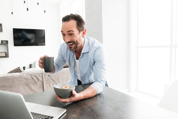 Heureux homme mature ayant un petit déjeuner sain