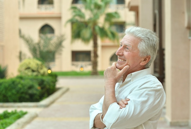 Heureux homme mûr en vacances pensant et souriant