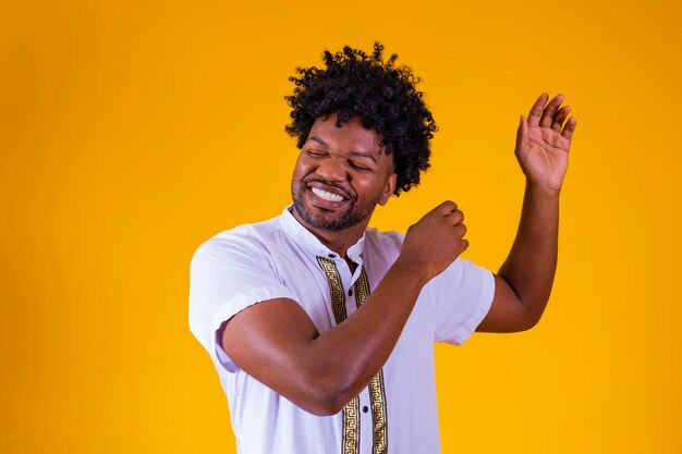 Photo heureux homme noir dansant sur fond jaune
