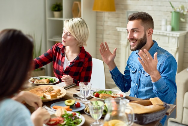 Heureux homme racontant des histoires à table