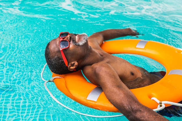 Heureux homme senior faisant la fête dans la piscine