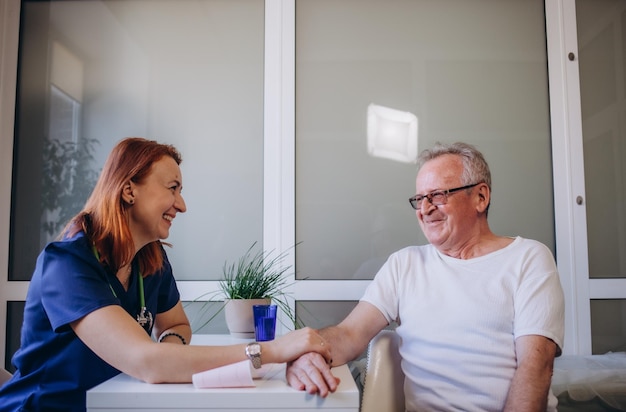 Heureux homme senior optimiste des années 80 regardant la caméra avec un sourire à pleines dents lors d'un rendez-vous au cabinet du médecin