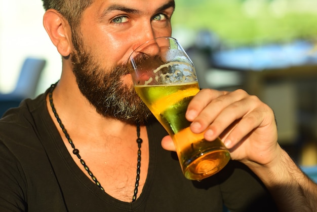 Heureux homme souriant avec une grande chope de bière à la main