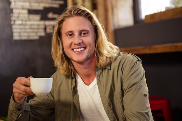 Photo heureux homme tenant une tasse de café