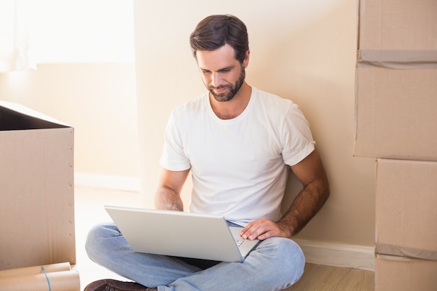 Heureux homme utilisant un ordinateur portable entouré de boîtes