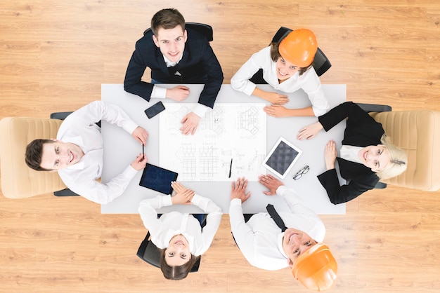 Les heureux ingénieurs travaillent avec un dessin sur la table. vue d'en-haut