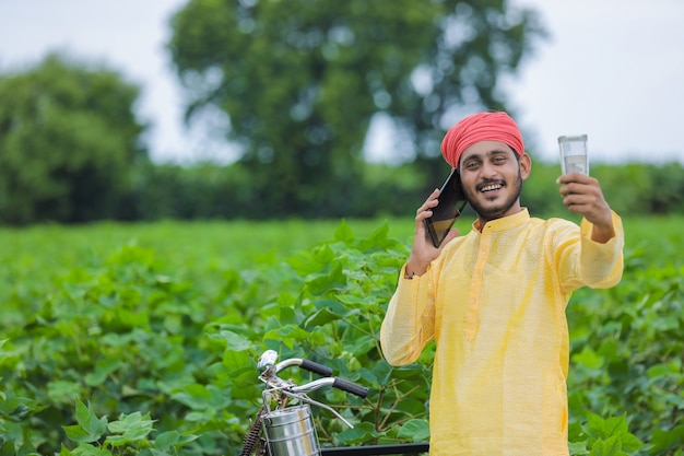 Heureux jeune agriculteur indien comptant et montrant de l'argent