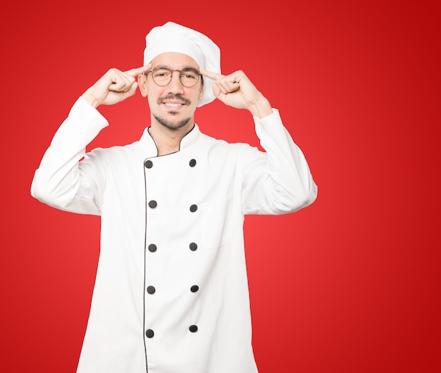 Heureux jeune chef faisant un geste de concentration