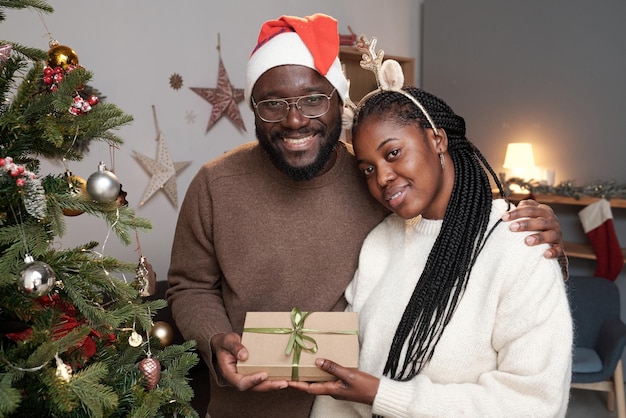 Heureux jeune couple africain en tenue décontractée et bonnet et bandeau de Noël