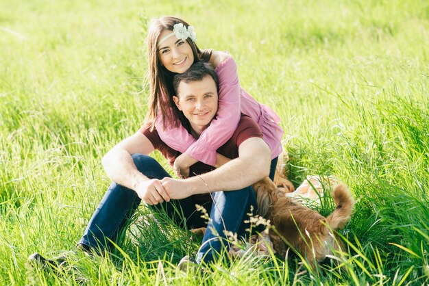 Heureux jeune couple aimant passer du temps dans le parc assis sur une pelouse verte par une journée d'été ensoleillée