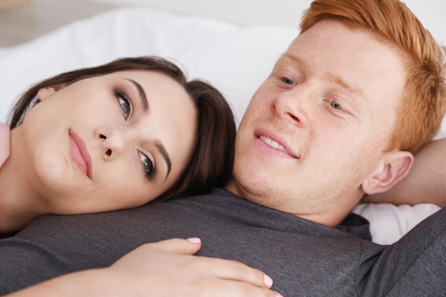 Heureux jeune couple allongé sur le lit