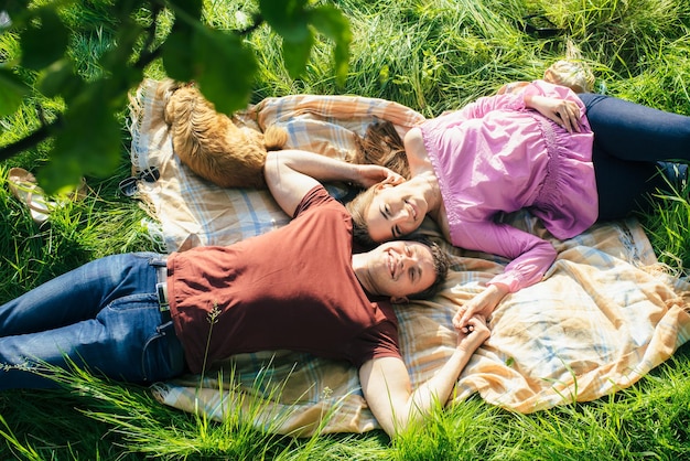Heureux jeune couple amoureux allongé sur l'herbe tête à tête Vue de dessus