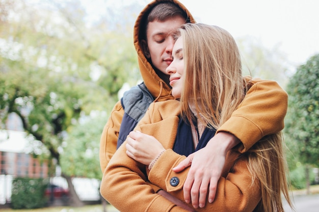 Heureux jeune couple amoureux amis adolescents habillés en style décontracté sur la rue de la ville en automne