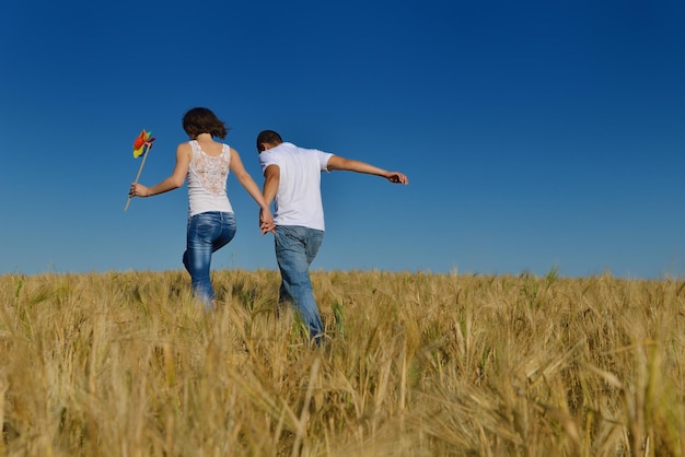 heureux jeune couple amoureux avoir de la romance et s'amuser au champ de blé en été