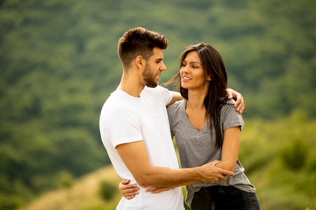 Heureux jeune couple amoureux sur le terrain en herbe un jour d'été