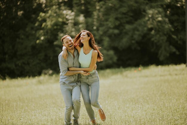 Heureux jeune couple amoureux sur le terrain en herbe