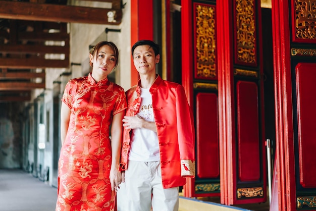 Heureux jeune couple asiatique en robes traditionnelles chinoises