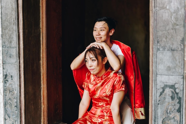 Heureux jeune couple asiatique en robes traditionnelles chinoises