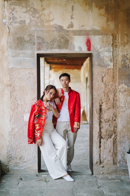 Heureux jeune couple asiatique en robes traditionnelles chinoises